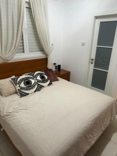 a bed with a pillow with an eye on it at Awesome Apartment Netanya in Netanya