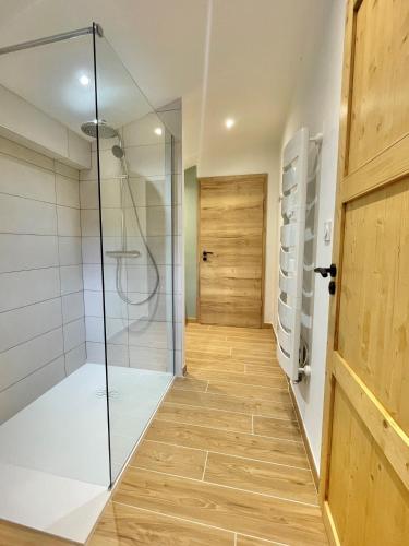 une salle de bain avec douche et porte vitrée dans l'établissement Gîte 15 personnes Sauna et Spa, à Le Thillot