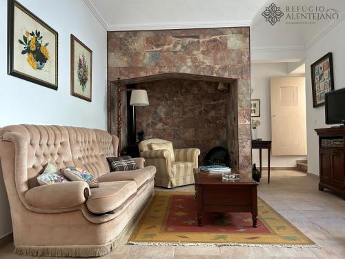 a living room with a couch and a fireplace at Refúgio Alentejano in Arraiolos