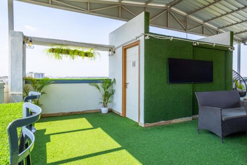 a living room with a green wall with a tv at Housr Charlie, HSR Layout Bengaluru in Bengaluru