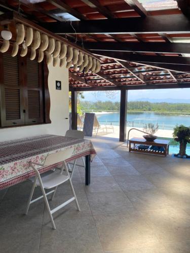 a patio with a table and a view of the water at Casa da Vovó - Barra Guaratiba in Rio de Janeiro