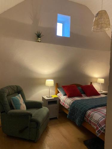 a bedroom with a bed and a chair and a window at Tigh George in Lettermore