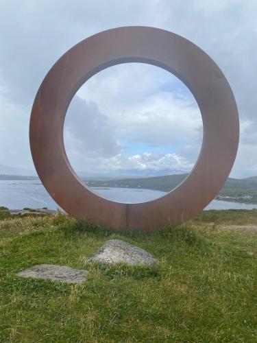 a circular metal sculpture on top of a field at Tigh George in Lettermore