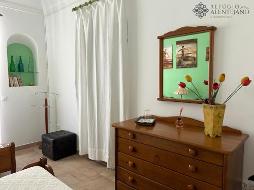 a bedroom with a dresser and a mirror on a dresser at Refúgio Alentejano in Arraiolos