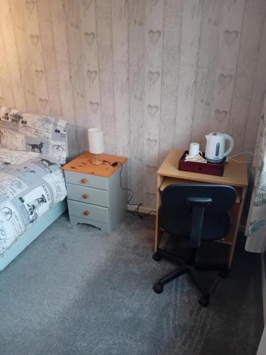 a bedroom with a desk and a bed and a chair at Family room in Broadstone