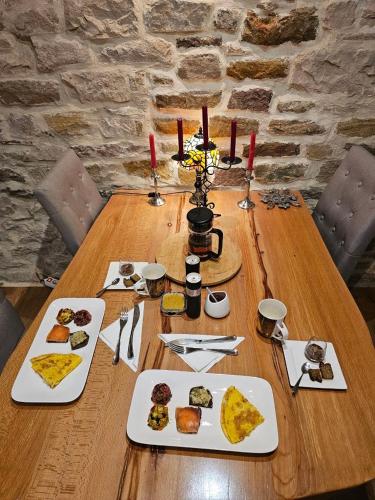 une table en bois avec des assiettes de nourriture dessus dans l'établissement Coin de bien-être à Ronchamp, à Ronchamp
