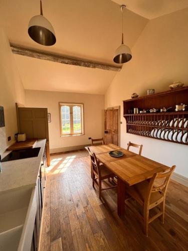 a kitchen and dining room with a wooden table at Apartment at Llanerchydol Hall in Welshpool