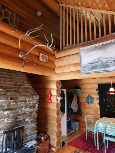 a room with a stone fireplace in a log cabin at Villa Tammukka in Inari