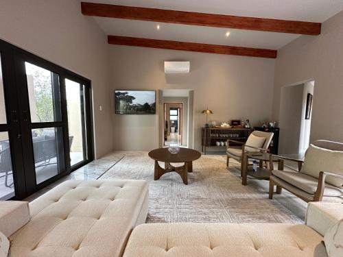 a living room with a couch and a table at Oase by 7 Star Lodges - Greater Kruger Private 530ha Reserve in Hoedspruit