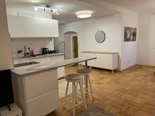 a kitchen with a counter and stools in a room at Masionette Wohnung in Weinregion 30 min südlich von Wien in Gumpoldskirchen