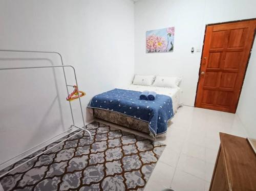 une chambre avec un lit avec des draps bleus et une porte dans l'établissement D'Amal Homestay Alor Setar, à Alor Setar