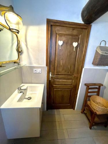 La salle de bains est pourvue d'un lavabo et d'une porte en bois. dans l'établissement Piana, à Porto-Vecchio