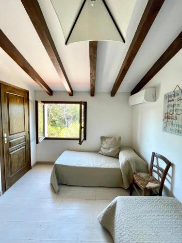 une chambre avec deux lits et une fenêtre dans l'établissement Piana, à Porto-Vecchio