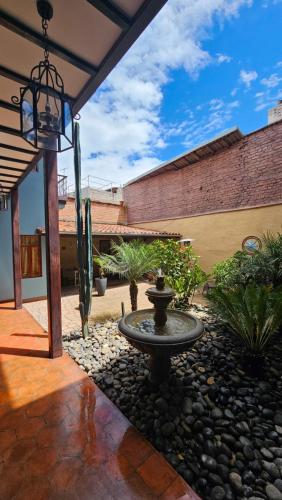 a courtyard with a fountain and plants and a building at Casa Hibiscus Boutique Hotel in Cuenca