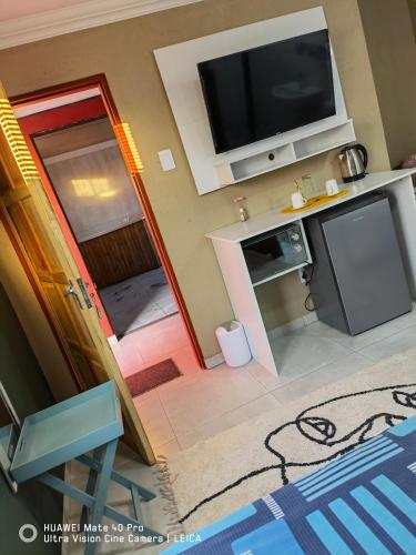 a view of a living room with a flat screen tv at Fresh Ideas GuestHouse in Soshanguve