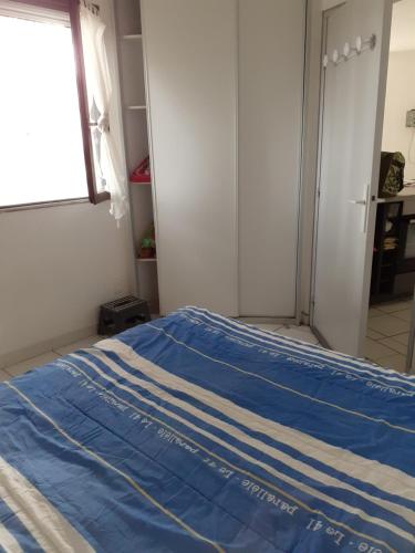 - une chambre avec un lit doté d'une couverture bleue dans l'établissement Appartement Barcares, au Barcarès