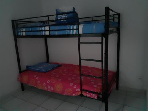 Cette chambre comprend 2 lits superposés et un lit rouge. dans l'établissement Appartement Barcares, au Barcarès