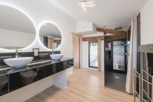 a bathroom with two sinks and two mirrors at Maison Muruzabal Etxea in Espelette