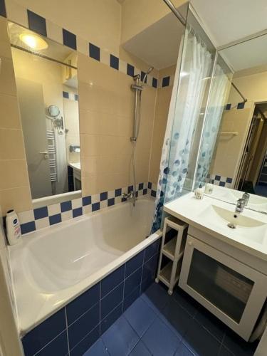 une salle de bain avec une baignoire, un lavabo et une douche dans l'établissement ApparthotelParisDefenseArenaElyseeEiffel, à Courbevoie