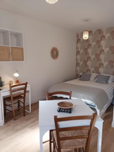 une chambre avec un lit, une table et des chaises dans l'établissement Studio 4 Calme et Moderne Proche des Thermes, à Rochefort
