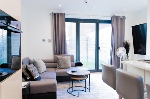 a living room with a couch and a table at Modern Entire Unit 3BR, 3BA, balcony, 86inch TV - 15mins to city in Romford