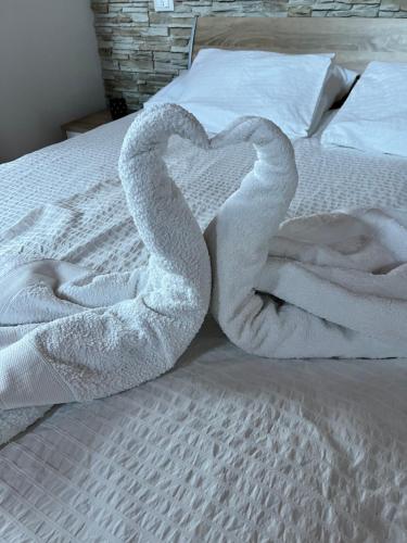 two swans are forming a heart on a bed at Casa Vacanza CADORNA RESIDENCE in Tarvisio