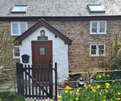 a house with a wooden door and a fence at Character cottage with spectacular views in Church Stoke