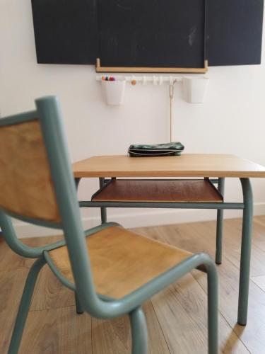une table en bois et une chaise avec un bureau dans l'établissement Cadre Verdoyant et Plage à Pied, à Le Minihic-sur-Rance