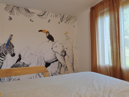 - une chambre avec une fresque murale représentant des oiseaux et un éléphant dans l'établissement Cadre Verdoyant et Plage à Pied, à Le Minihic-sur-Rance