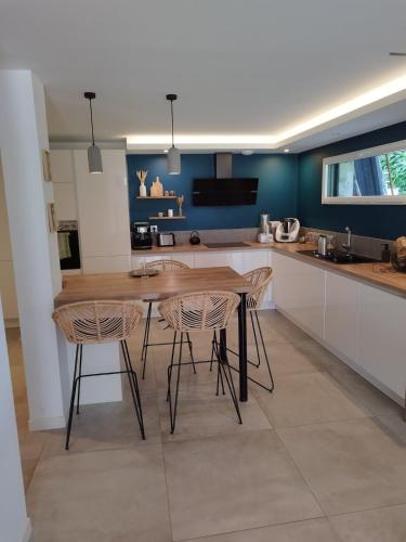 une cuisine avec une table en bois et deux chaises dans l'établissement Cadre Verdoyant et Plage à Pied, à Le Minihic-sur-Rance