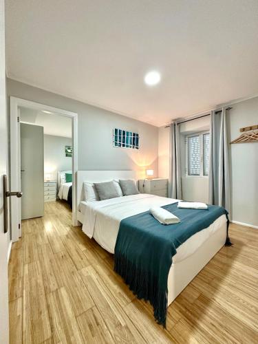 a bedroom with a large bed with a blue blanket at Casa do Perestrelo - Guest House in Machico