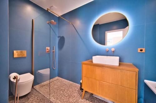 une salle de bain bleue avec un lavabo et un miroir dans l'établissement Port of Nice - Scooters Included, à Nice