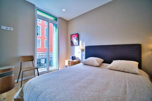 une chambre avec un grand lit avec une grande fenêtre dans l'établissement Port of Nice - Scooters Included, à Nice