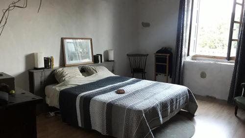 une chambre avec un lit avec une couverture bleue et blanche dans l'établissement Loft Sur l'Alzeau, à Montolieu