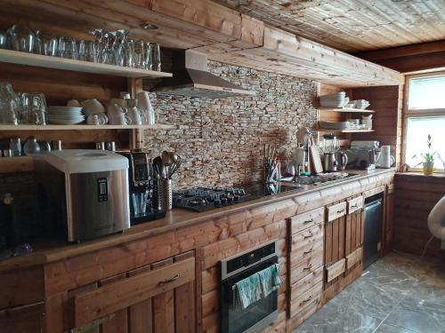 a kitchen with wooden cabinets and a counter top at Beskiden Prime Exclusiv Chalets in Prostřední Bečva