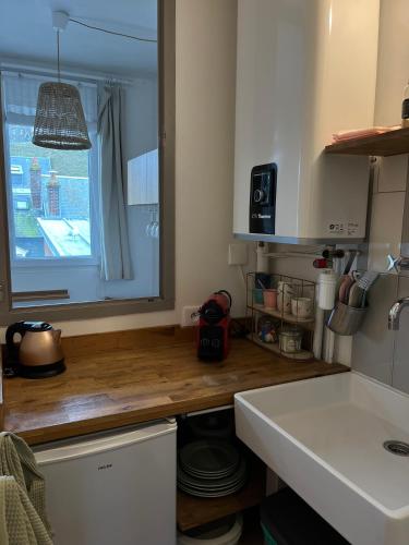 une cuisine avec un comptoir et une fenêtre dans l'établissement La Perle des Falaises, au Tréport