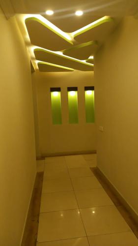 an empty room with green lights on the ceiling at booking at lodges in Lahore