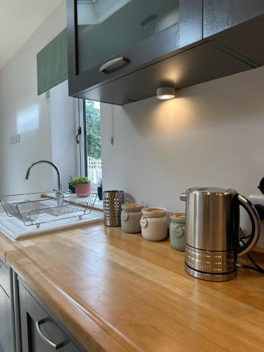 a kitchen counter with a pot on a wooden counter top at Poppy Cottage, Mawdesley Village in Mawdesley