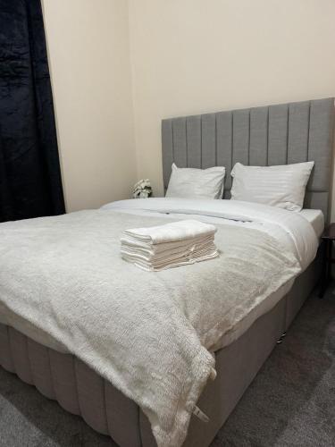 a bed with white blankets and pillows on it at 2 Bed Apartment city centre in Wolverhampton
