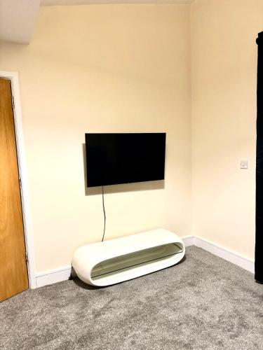 a room with a bed with a flat screen tv on the wall at 2 Bed Apartment city centre in Wolverhampton