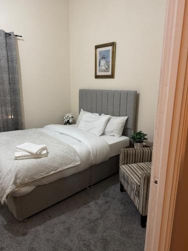 a bedroom with a bed and a chair at 2 Bed Apartment city centre in Wolverhampton