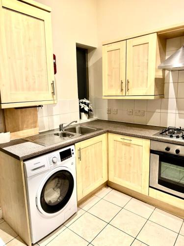 a kitchen with a washing machine and a sink at 2 Bed Apartment city centre in Wolverhampton