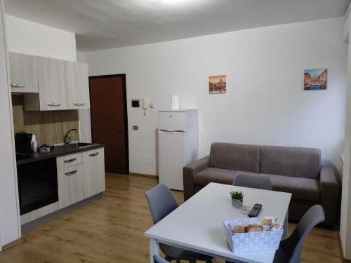 a kitchen and a living room with a table and a couch at Casa CHANEL in Latina