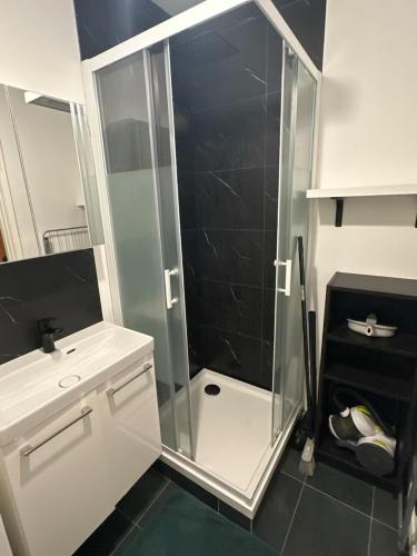 une douche avec une porte vitrée dans une salle de bain dans l'établissement Un coin pour deux, à Saint-Brieuc