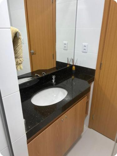 a bathroom with a sink and a mirror at Apartamento Confortável e Espaçoso em Condomínio Familiar, 2 Quartos com 1 suíte e Lazer de Clube in Belém