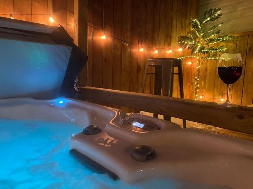 a hot tub with a glass of wine and a glass of red wine at Jeans Place A Hot tub Oasis in Lewisporte