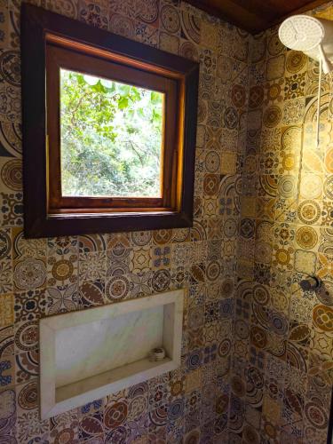 a bathroom with a window on a wall at Pousada da Fonte in Lençóis