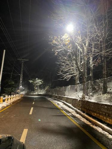 an empty street at night with a street light at SUPERHOST Apartments - Near GPO & Mall Road in Murree