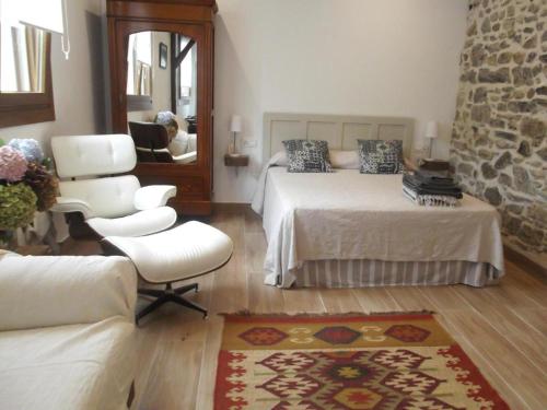 a bedroom with a bed and a chair and a mirror at Anikuenea Estudio Anbita in Lesaka