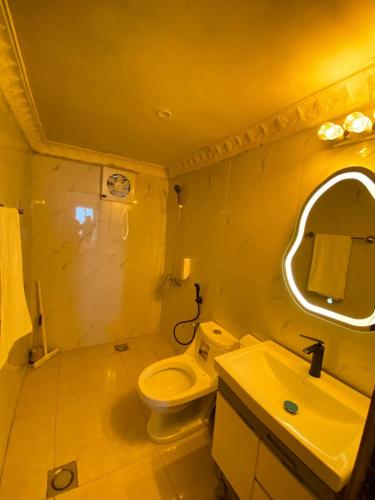 a bathroom with a toilet and a sink and a mirror at SUPERHOST Apartments - Near GPO & Mall Road in Murree